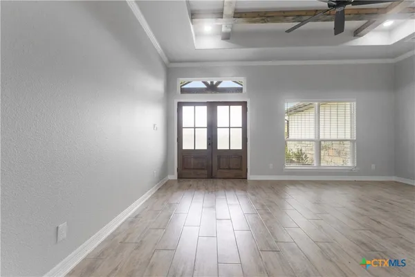 a view of empty room with wooden floor and fireplace