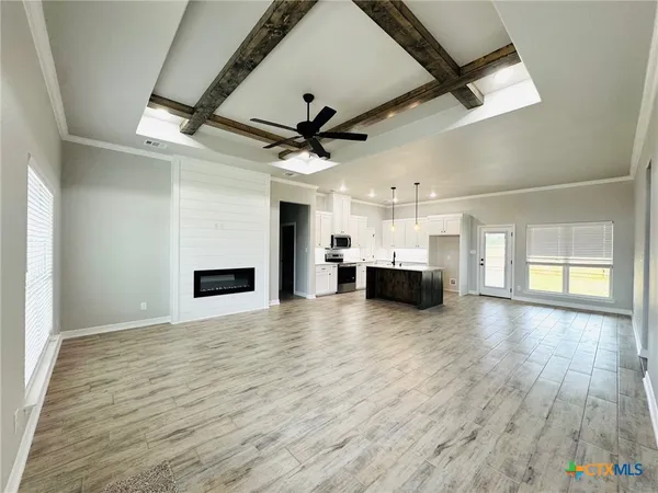 a large kitchen with stainless steel appliances kitchen island a large counter top and a wooden floor