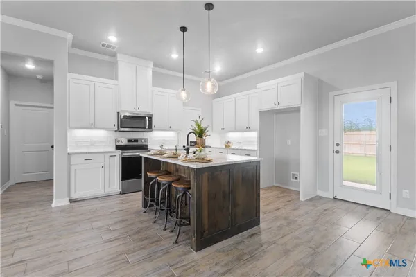 a large kitchen with cabinets wooden floor and stainless steel appliances