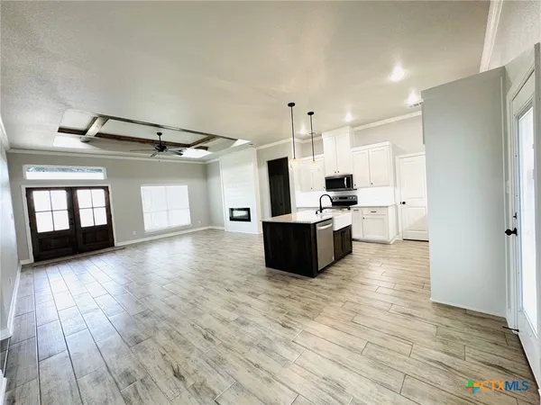 a kitchen with stainless steel appliances a sink a stove a refrigerator and cabinets