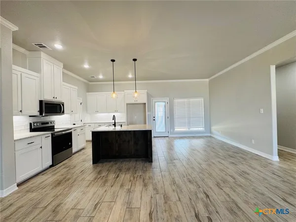a kitchen with white cabinets a sink and dishwasher