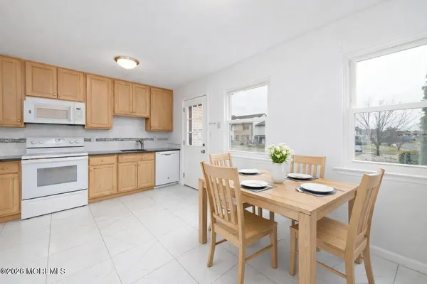 a kitchen with a stove a sink a table and chairs