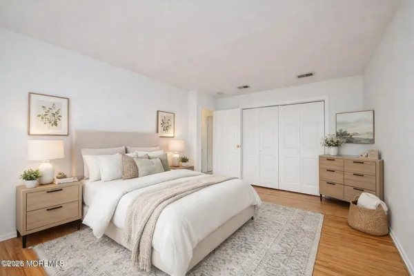 a bedroom with a bed and wooden floor