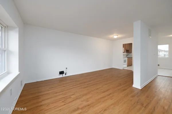 a view of empty room with wooden floor