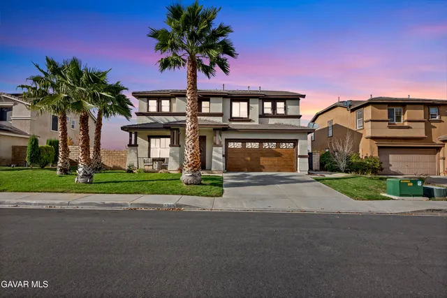 a front view of a house with a garden and trees