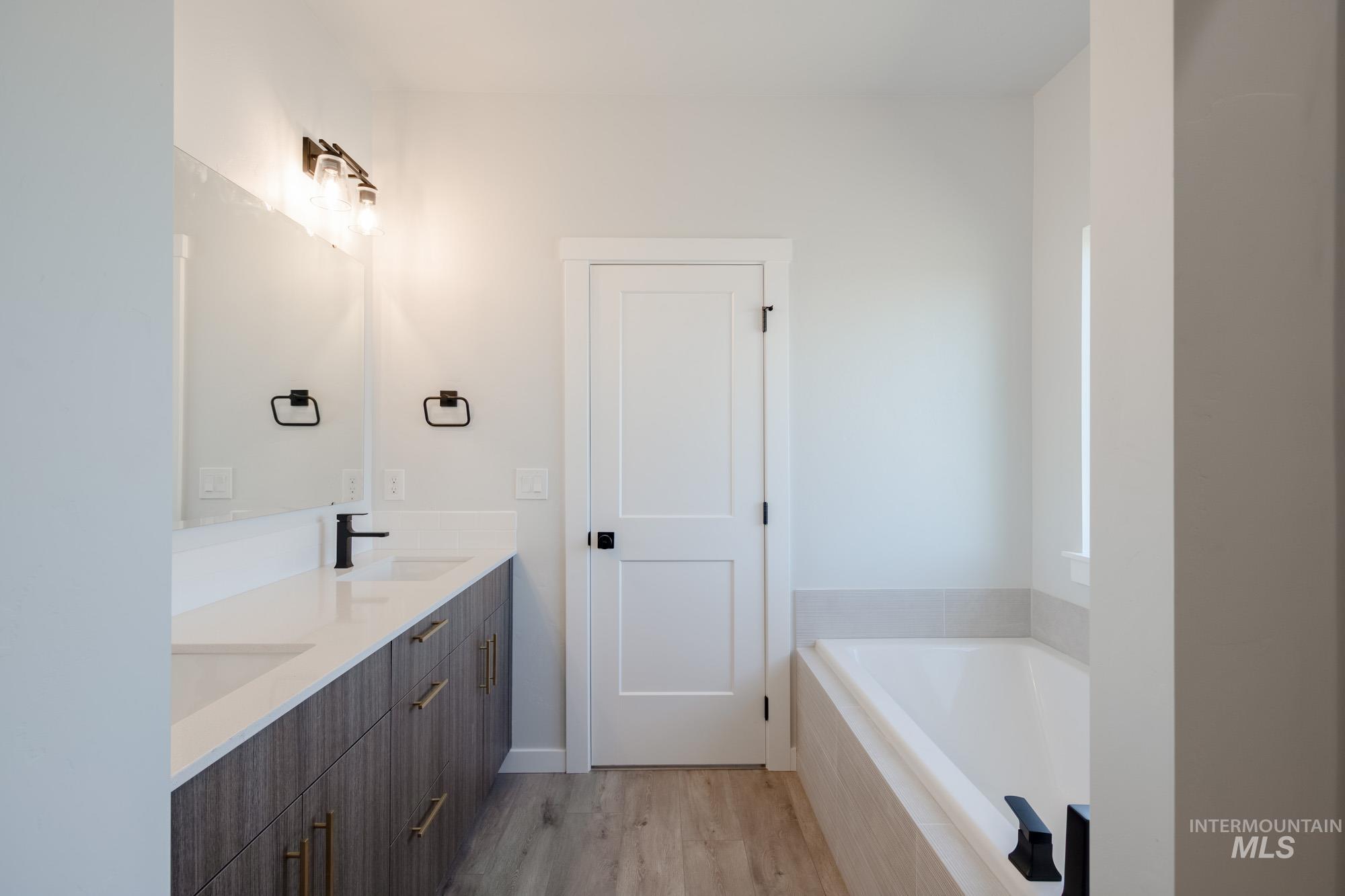 2231 South Border Way Meridian, ID 83642 - Photo 19 of 23 Full bath with double vanity, light wood-style floors, and a garden tub