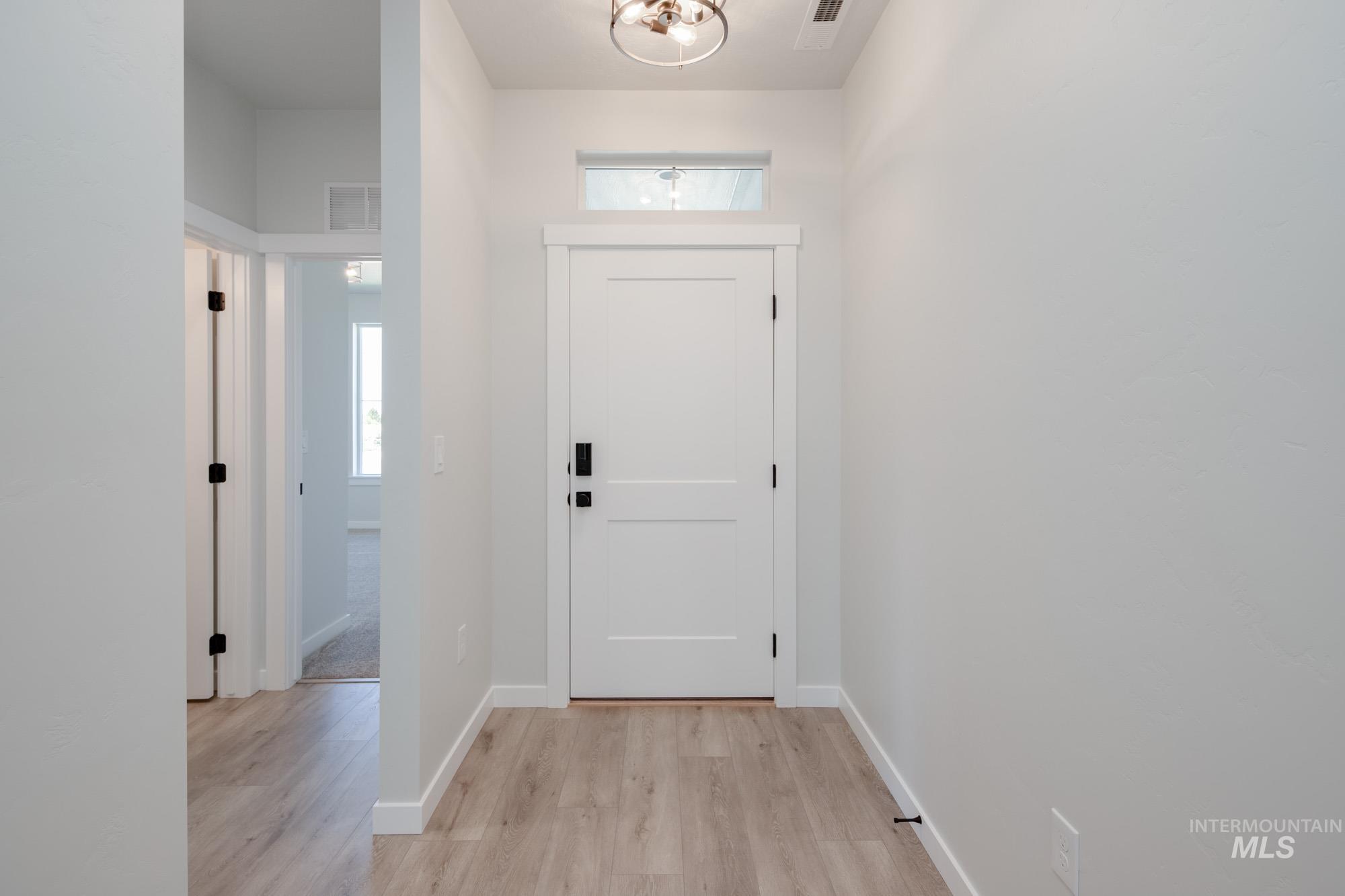 2231 South Border Way Meridian, ID 83642 - Photo 2 of 23 Entryway with light wood-type flooring and a chandelier