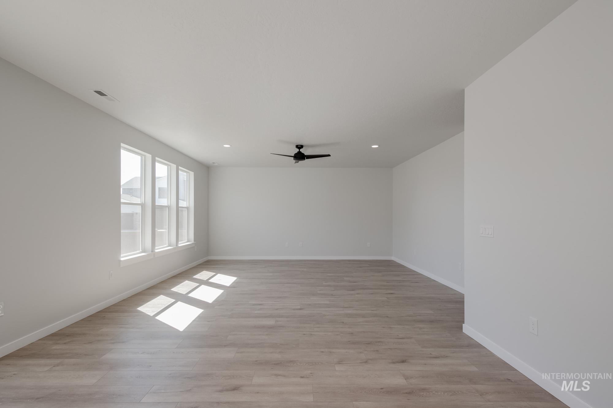2231 South Border Way Meridian, ID 83642 - Photo 6 of 23 Empty room with light wood finished floors, a ceiling fan, and recessed lighting