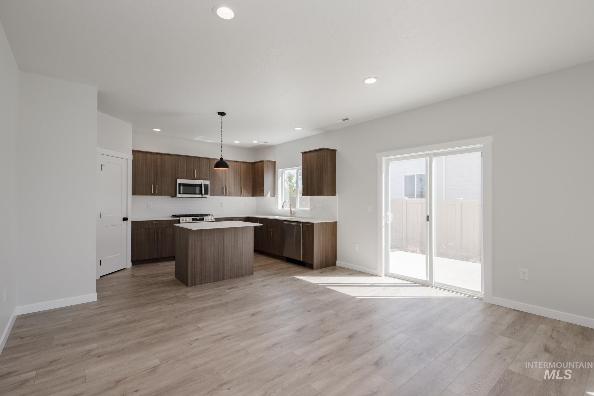 2231 South Border Way Meridian, ID 83642 - Photo 7 of 23 Kitchen featuring pendant lighting, light countertops, a kitchen island, stainless steel appliances, and modern cabinets