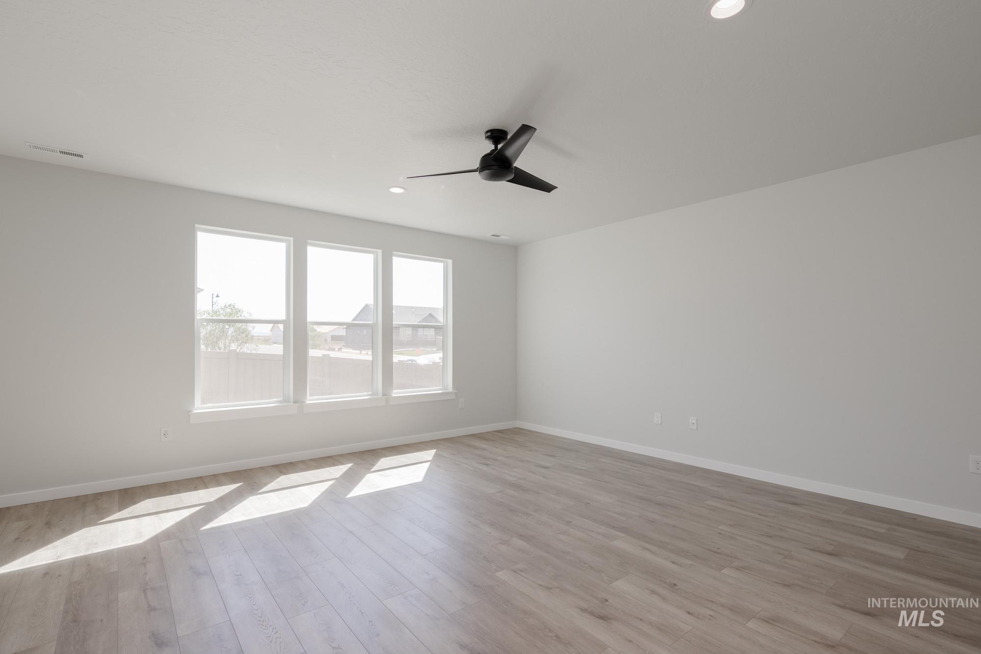 2231 South Border Way Meridian, ID 83642 - Photo 8 of 23 Empty room with light wood-style floors, ceiling fan, and recessed lighting