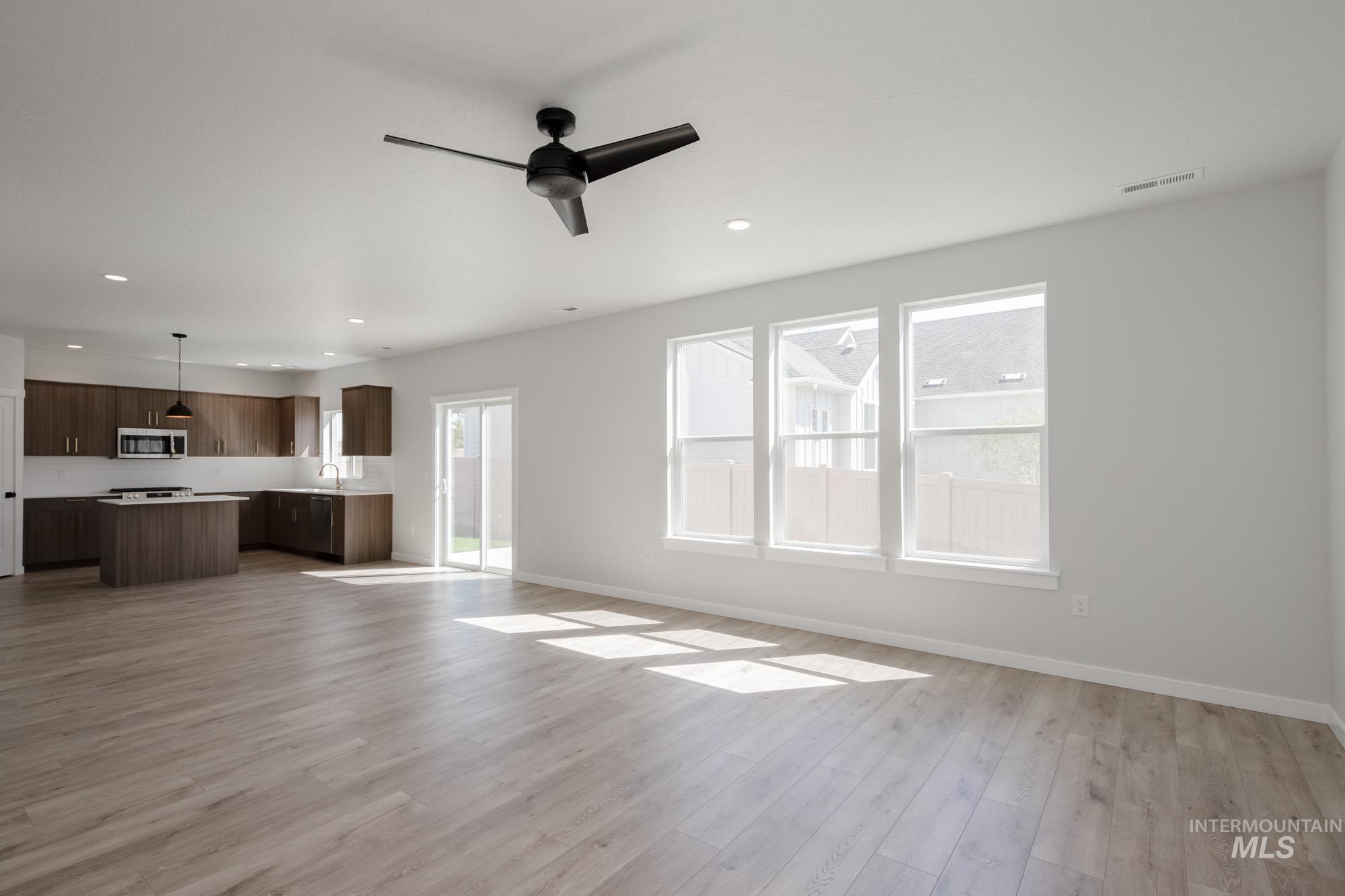 2231 South Border Way Meridian, ID 83642 - Photo 10 of 23 Unfurnished living room featuring a ceiling fan, light wood-style flooring, and recessed lighting
