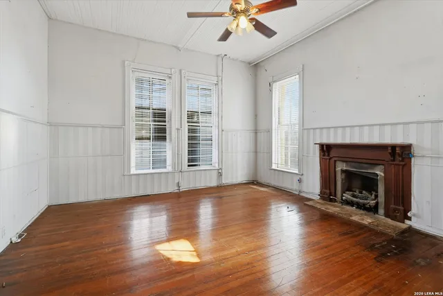 an empty room with windows and fireplace
