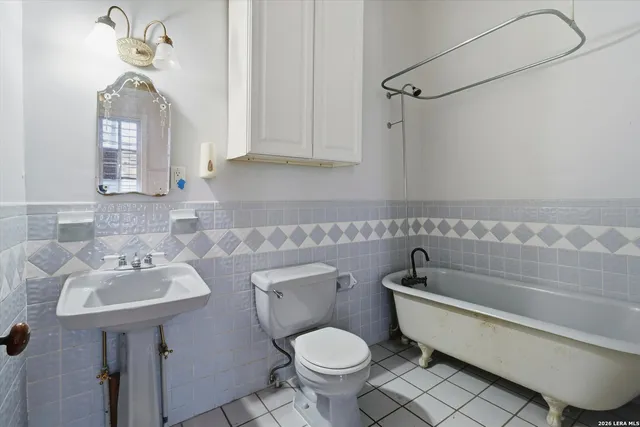 a bathroom with a toilet mirror and vanity