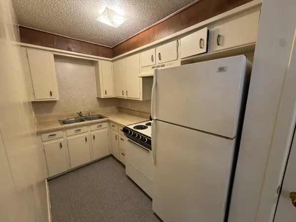 a white refrigerator freezer sitting inside of a kitchen