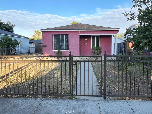 front view of a house with a wrought fence