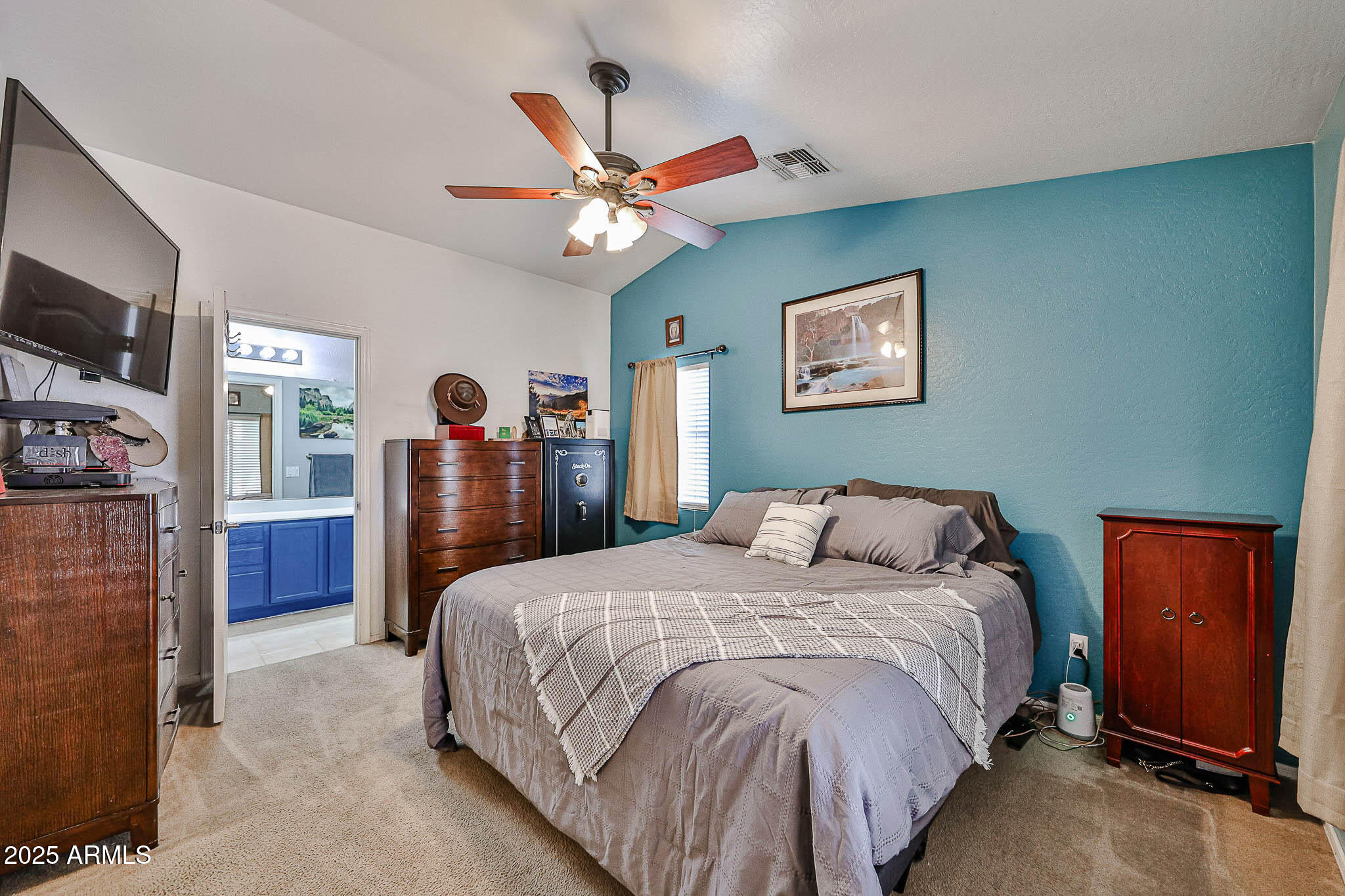 17845 West Calavar Road Surprise, AZ 85388 - Photo 16 of 26 a bed room with a bed and a television