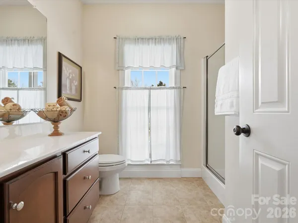 a bathroom with a granite countertop sink a toilet and a shower