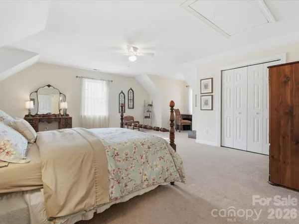 a spacious bedroom with a bed a ceiling fan and a couch
