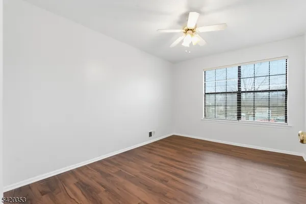 an empty room with a window and a fan