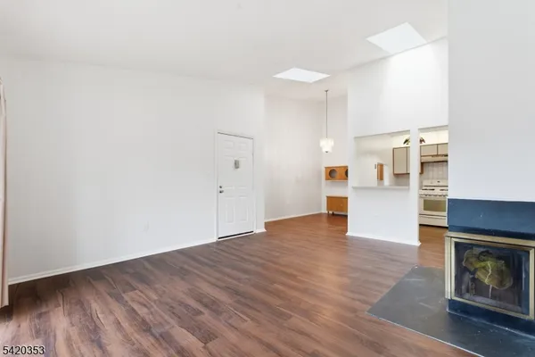 a view of a kitchen with wooden floor and a refrigerator