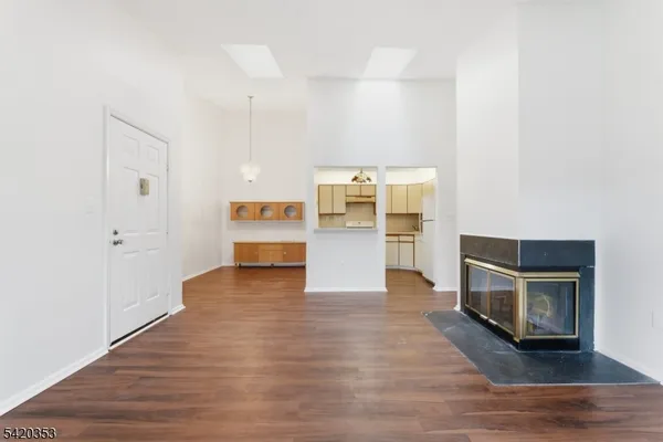 a view of a kitchen with wooden floor and a refrigerator