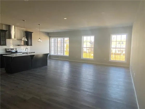 an open kitchen with wooden floor and cabinets
