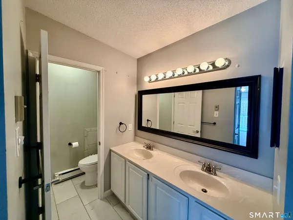 a bathroom with a toilet sink and mirror