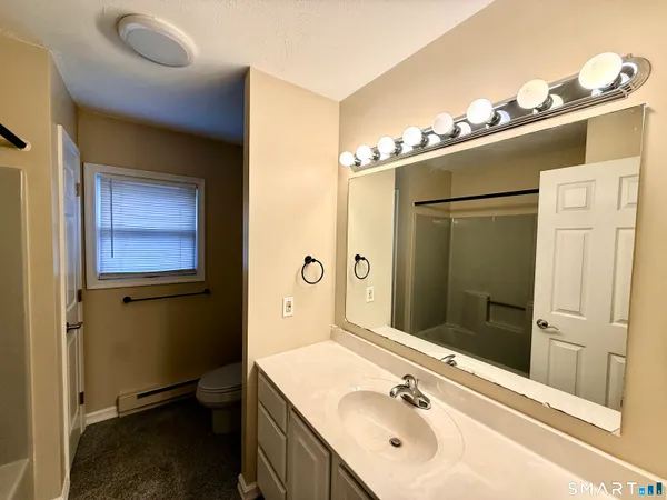 a bathroom with a tub sink and mirror