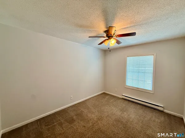 an empty room with a window and a fan