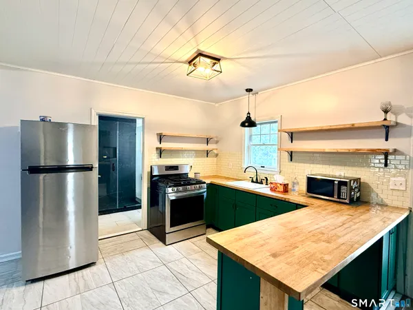 a kitchen with stainless steel appliances granite countertop a refrigerator a sink and dishwasher