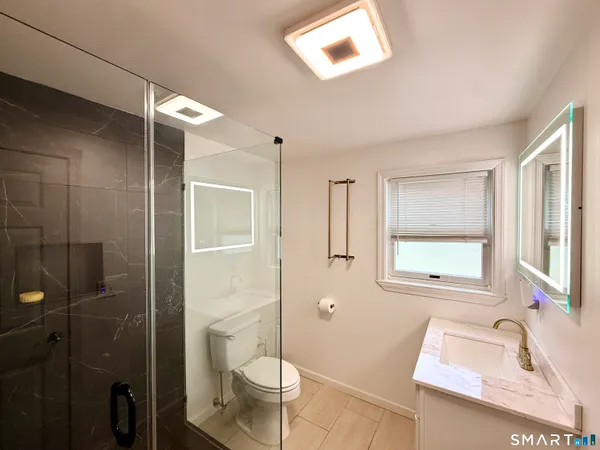 a bathroom with a sink toilet and shower