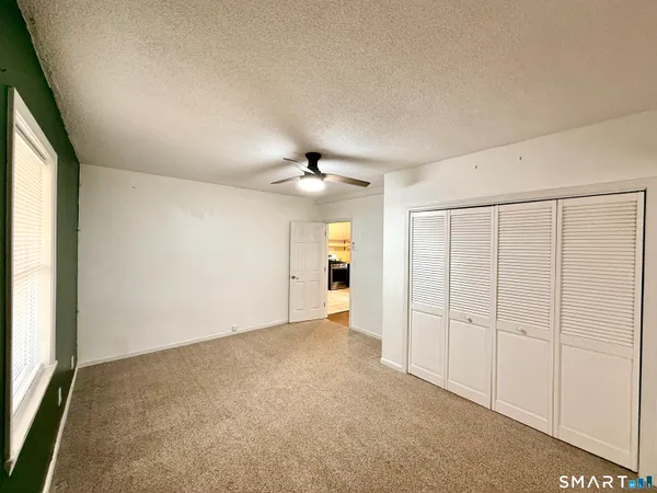 an empty room with a ceiling fan and a window