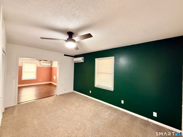 en empty room with windows and ceiling fan