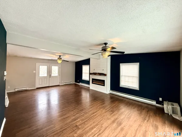 a view of empty room with wooden floor and fireplace