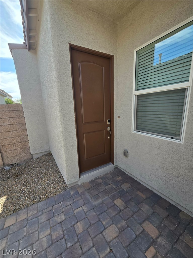 4748 Ritual Street North Las Vegas, NV 89031 - Photo 7 of 31 A private entryway boasts textured pavers leading to a welcoming front door.