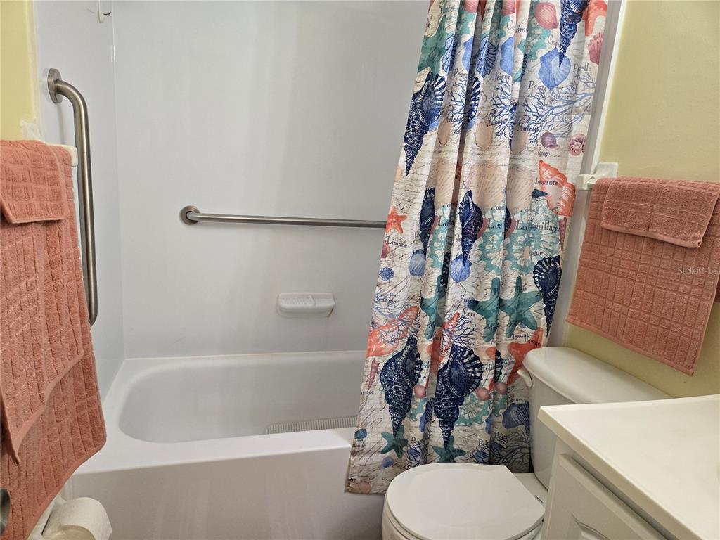 5925 Terrace Park Drive North, Unit 106 St. Petersburg, FL 33709 - Photo 12 of 22 a bathroom with a toilet and a shower