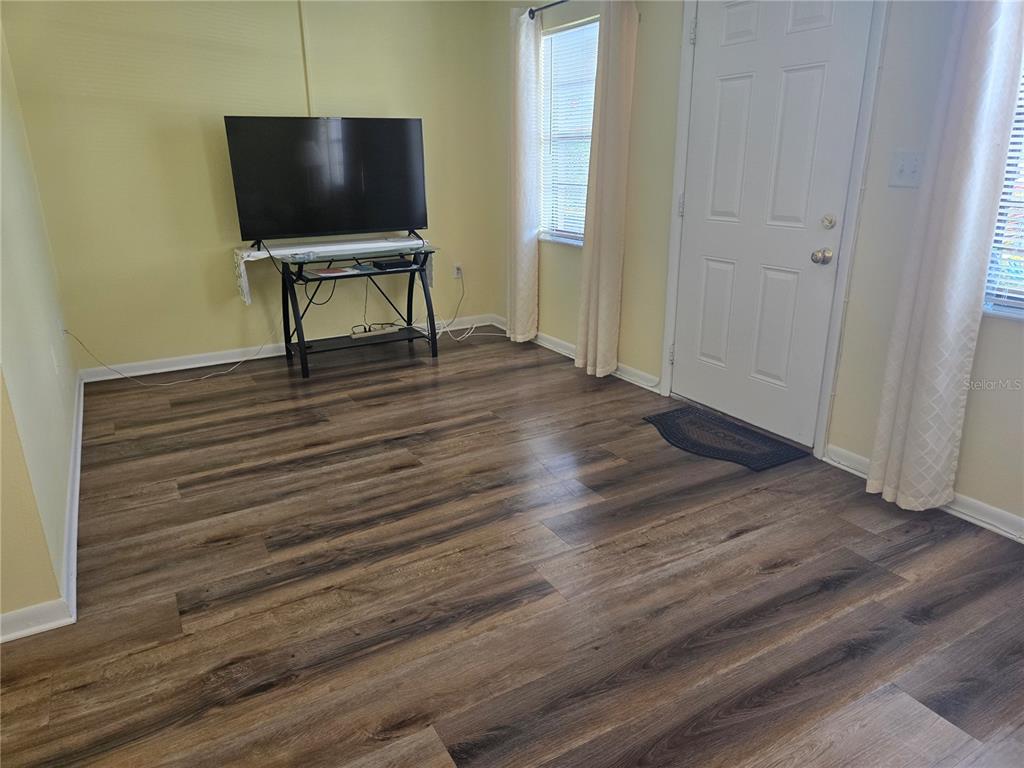 5925 Terrace Park Drive North, Unit 106 St. Petersburg, FL 33709 - Photo 5 of 22 a living room with furniture and a flat screen tv