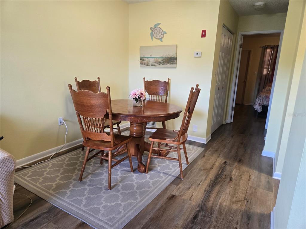 5925 Terrace Park Drive North, Unit 106 St. Petersburg, FL 33709 - Photo 6 of 22 a dining room with furniture and wooden floor