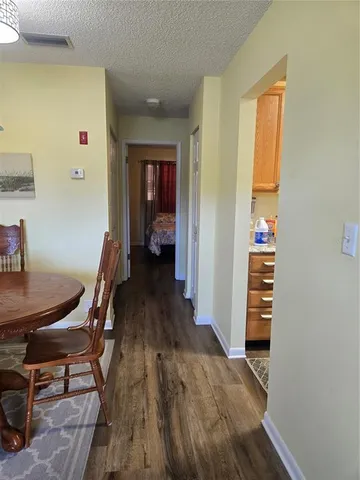 a view of a hallway with wooden floor and furniture