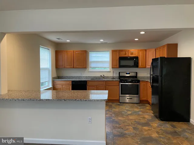 a kitchen with stainless steel appliances granite countertop a refrigerator and a stove