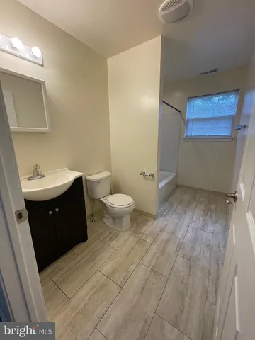 a spacious bathroom with a double vanity sink toilet and a mirror