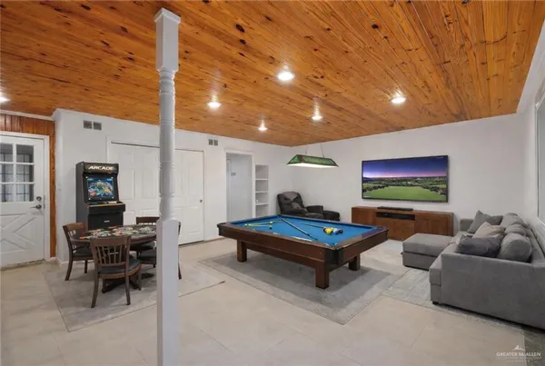 a living room with furniture pool table and a rug