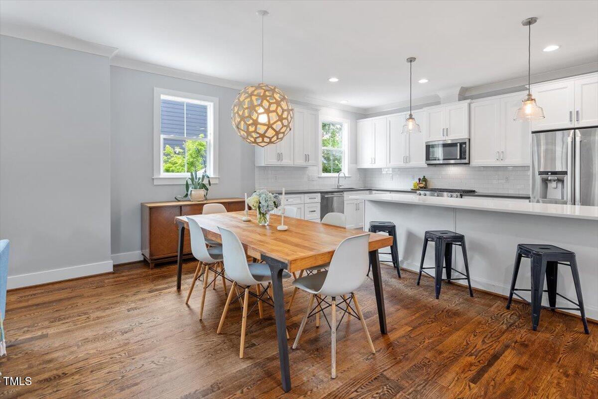 811 East Lane Street Raleigh, NC 27601 - Photo 13 of 35 a view of a dining room and a kitchen with a table chairs a workspace