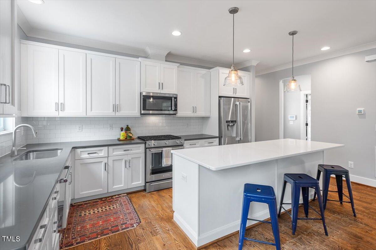 811 East Lane Street Raleigh, NC 27601 - Photo 14 of 35 a kitchen with a refrigerator a stove a sink a dining table and chairs