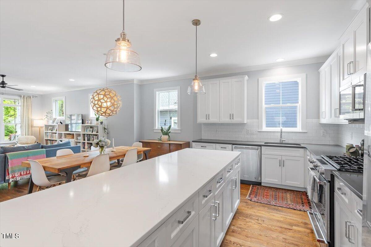 811 East Lane Street Raleigh, NC 27601 - Photo 15 of 35 a large kitchen with kitchen island a large counter space a sink stainless steel appliances and cabinets