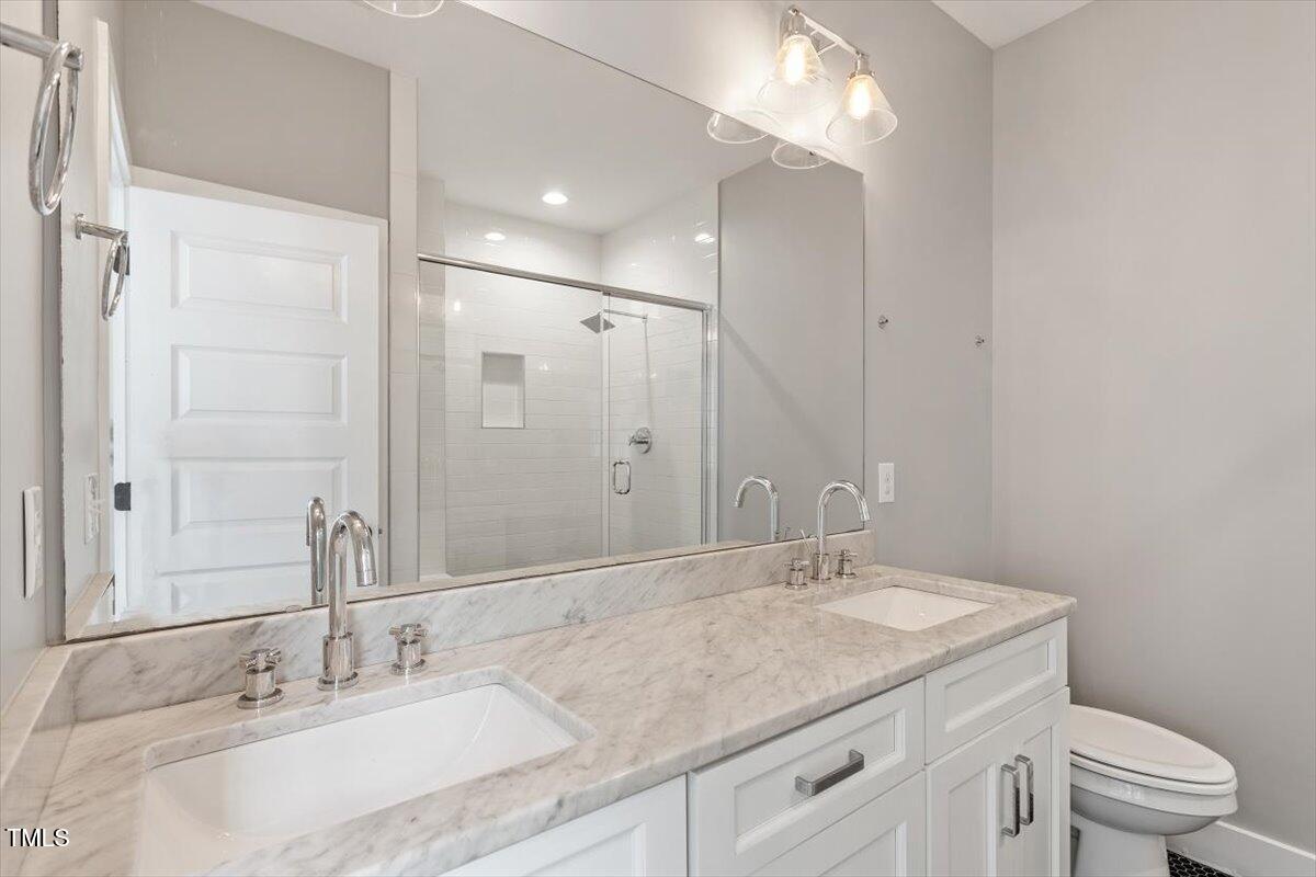 811 East Lane Street Raleigh, NC 27601 - Photo 30 of 35 a bathroom with a granite countertop sink a toilet and a mirror