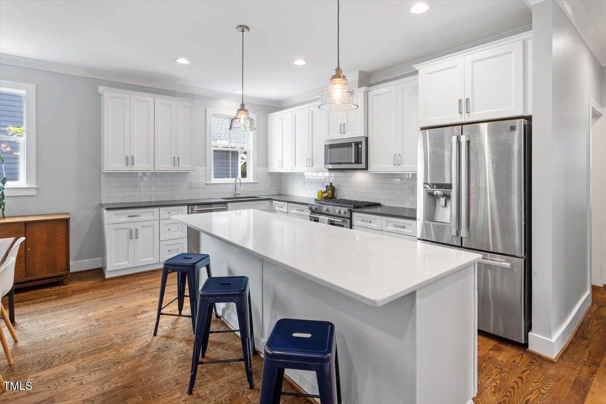 811 East Lane Street Raleigh, NC 27601 - Photo 34 of 35 a kitchen with stainless steel appliances granite countertop a refrigerator a sink a stove a dining table and chairs