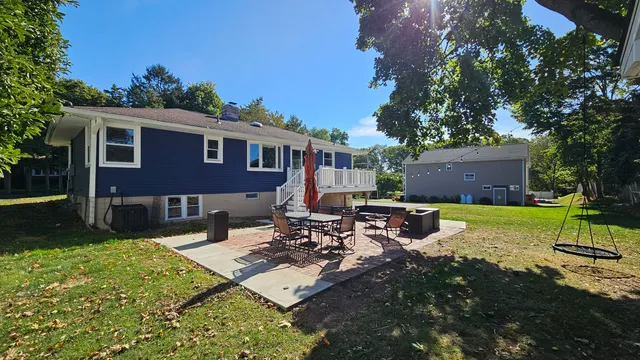 a view of a house with backyard sitting area and garden