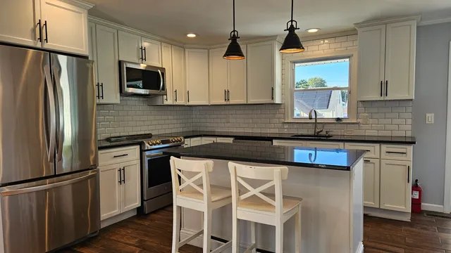 a kitchen with stainless steel appliances a sink stove refrigerator and cabinets