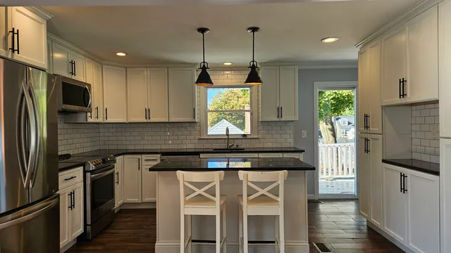 a kitchen with kitchen island granite countertop a stove and a refrigerator